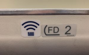 A Wi-Fi symbol on an overhead bin, indicating the presence of IFC onboard