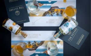 Two small Tom Savano drink bottles lay split over passports and images of beach destinations.