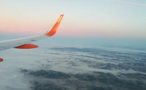 A veiw of a sunset out the window of an easyJet aircraft. An easyJet wingtip is visible in the view.