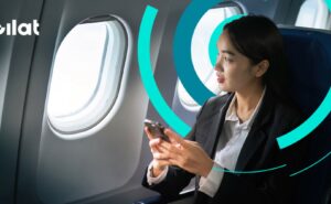 A woman is using her mobile device in flight. Gilat's logo is seen above the image.